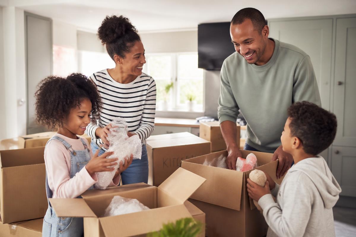 A family unpacking moving boxes together in the kitchen of their new home